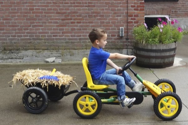 BERG Gokart Buddy John Deere mit Trailer / kleinem Anhänger mit Stroh gefüllt und einem Jungen als Fahrer